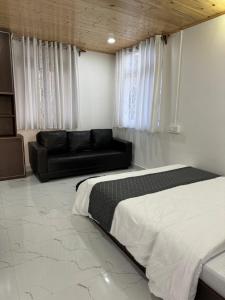 1 dormitorio con cama y sofá en Addy's Inn en Gangtok