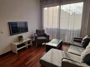 a living room with a couch and a chair and a television at El Atico de Sabadell muy Cerca del Centro in Sabadell +3 photos
