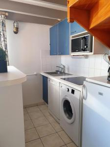 a kitchen with a washing machine and blue cabinets at Duplex 6-7 p Résidence proche plage in La Couarde-sur-Mer