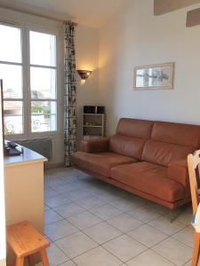 a living room with a brown couch in a room at Duplex 6-7 p Résidence proche plage in La Couarde-sur-Mer