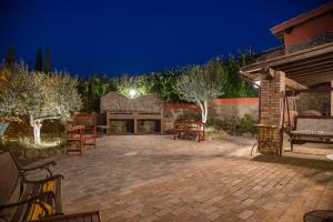 a patio with benches and a fireplace at night at Country House Style in Montefiascone