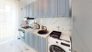 a kitchen with a washing machine and a sink at Serenity Retreats VRT in Sibiu