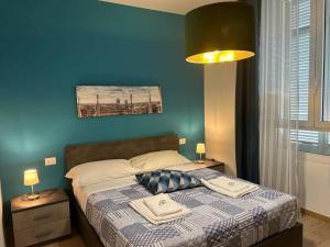 Schlafzimmer mit einem Bett mit blauer Wand in der Unterkunft Bayres Blue in Mailand