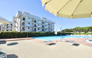 una piscina con 2 sillas y un edificio en ISA-Apartments for 4 people, 2 bedrooms, in Residence with swimming pool in San Vincenzo, just 600 meters from the sea, en San Vincenzo