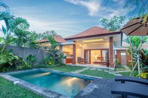 a villa with a swimming pool in front of a house at Palasari Villa in Tegalalang