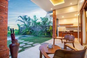 un patio con tavolo e sedie e un giardino di Palasari Villa a Tegalalang