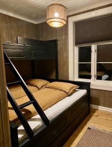 a bedroom with a bunk bed and a window at Apotekbygget in Nesbyen