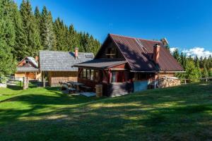 una grande casa in legno in cima a un campo verde di Mountain Lodge Jelje - Happy Rentals a Zgornje Gorje