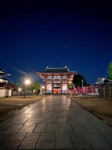 um templo asiático à noite com uma rua de calçada em ホテルハヌル em Osaka