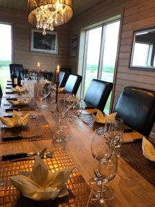 a dining room with a long table with wine glasses at Fishing Lodge Hálsakot in Sleðbrjótur