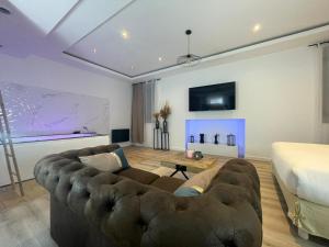 a living room with a couch and a bed at L'Eden Spa - Jacuzzi - Saint-Etienne in Saint-Étienne