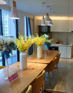 una mesa de madera con tres jarrones de flores. en Minsheng Apartment en Guangzhou