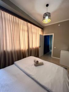 Un dormitorio con una cama con una toalla. en ЖК Ламия en Almaty