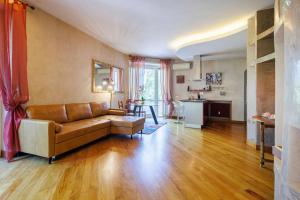 een woonkamer met een bruine bank en een keuken bij appartamento a Testaccio in Rome