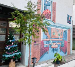 a christmas tree and a mural on the side of a building at MatchBox Hostel in Longjing