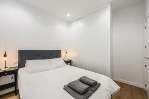 1 dormitorio con 1 cama blanca y 2 toallas en MyHouseSpain - Glamour y confort cerca del Retiro en Madrid