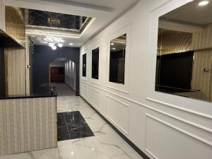 un corridoio di un edificio con pareti bianche e pavimenti piastrellati di ÇANKAYA SUIT HOTEL a Ankara