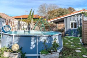 a pool in a yard with a swing at Chalet studio bassin d'arcachon in La Teste-de-Buch