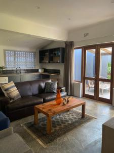 een woonkamer met een bank en een tafel bij Churchill Cottage in Gillitts