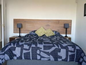 een slaapkamer met een bed met een blauwe en grijze quilt bij Churchill Cottage in Gillitts +4 foto's