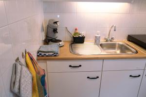 uma cozinha com um lavatório e uma bancada em 'T Heilige Pad em Egmond aan Zee