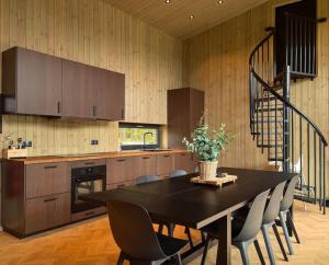 a kitchen with a table and chairs and a staircase at Skogly - Ny stor hytte, Unike Finnskogen in Torsby