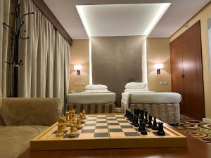 a room with a chessboard and a room with beds at فندق تحسين العزيزية-Tahseen Azizia Hotel in Mecca