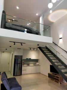 ein Wohnzimmer mit einer Treppe und eine Küche in der Unterkunft EkoCheras Duplex in Kuala Lumpur