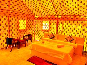 山姆Desert island Camp & Resort Jaisalmer的房间里有一张床和一张桌子的卧室
