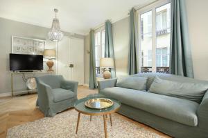 a living room with a couch and a table at Résidence Opéra by Studio prestige in Paris