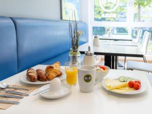 un tavolo con colazione a base di cornetti e succo d'arancia di B&B Hotel Stuttgart-City a Stoccarda