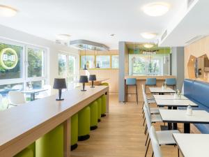 una sala da pranzo con tavoli e sedie di B&B Hotel Stuttgart-City a Stoccarda