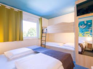 a bedroom with two bunk beds and a window at B&B Hotel Stuttgart-City in Stuttgart