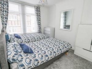 a bedroom with a bed with blue pillows and a window at Taylor’s Retreat in Radipole