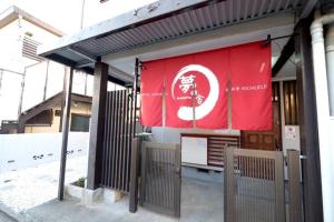 una pancarta roja al lado de un edificio en Daiichi Mitsumi Corporation - Vacation STAY 15393, en Musashino