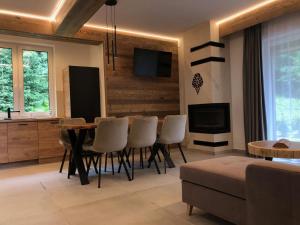 a living room with a dining room table and chairs at Prywatna Sauna i jacuzzi! Tatra Spa Witów in Witów