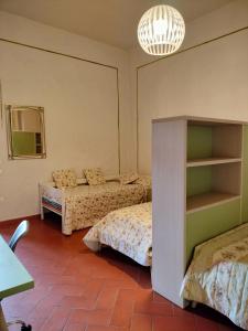 1 dormitorio con 2 camas y lámpara de araña en Foresteria San Niccolò, en Prato