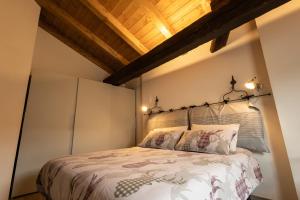 sypialnia z łóżkiem i drewnianym sufitem w obiekcie Maison Aubert in Centro Storico w Aoście