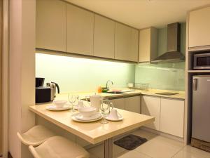 a kitchen with a table with wine glasses on it at Cormar KLCC by NHB in Kuala Lumpur