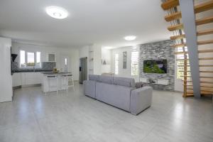 a living room with a couch and a kitchen at VILLA L'INDIA - Un havre de paix familiale in Labarthe