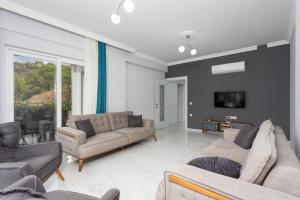 a living room with two couches and a tv at Villa Sasha 2 in Ortaca