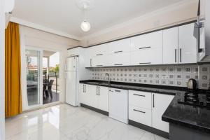 a kitchen with white cabinets and a large window at Villa Sasha 2 in Ortaca