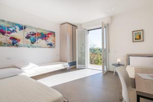 a white room with a bed and a desk and a window at Orizzonte 11 in Gabicce Mare