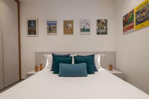 a bedroom with a large white bed with blue pillows at Orizzonte 11 in Gabicce Mare