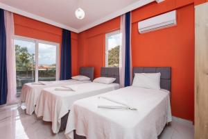 three beds in a room with orange walls and windows at Villa Sasha 2 in Ortaca +38 photos