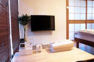 sala de estar con mesa y TV en la pared en Daiichi Mitsumi Corporation - Vacation STAY 15351, en Musashino