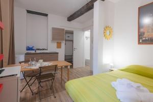 ジェノヴァにあるAppartamento Maddalena Basso - Affitti Brevi Italiaのベッドとテーブルとキッチンのある寝室