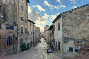 an alley in an old town with brick buildings at Casa Al Cantone in Certaldo