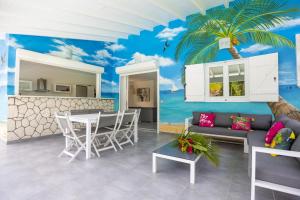 a living room with a palm tree mural at Les VILLAS AZULIA in Saint-François