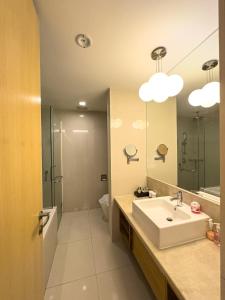 a bathroom with a sink and a shower and a mirror at Cormar KLCC by NHB in Kuala Lumpur